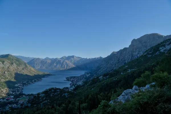 Zaliv Kotora pre izlaska sunca, pogled sa planinskog serpentina, sa mirnim vodama i buđenjem grada.