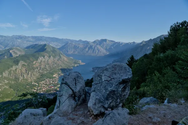 Scena mattutina della Baia di Kotor, Montenegro, vista da una strada di montagna con primo piano roccioso.