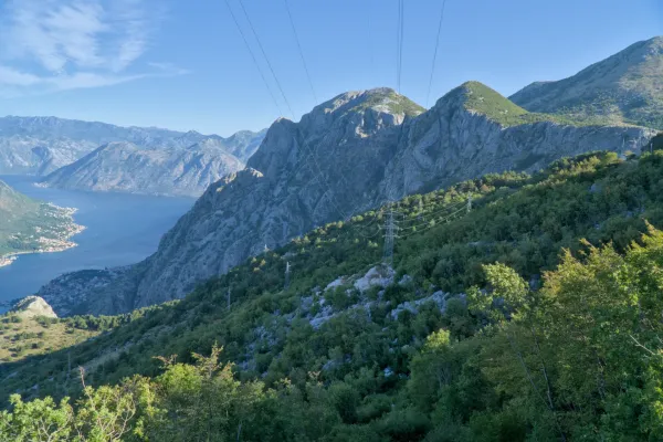 Planinski pejzaž koji gleda na Kotorski zaliv u zoru, okupano mekim svetlom.