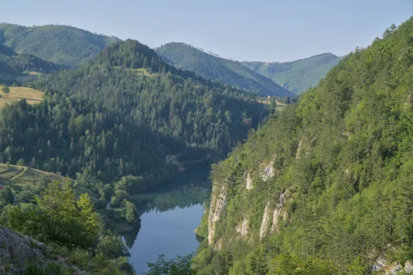 Der Spajići-See, aufgenommen von der Lazic-Talsperre im Nationalpark Tara, zeigt grüne Berge und ruhiges Wasser.