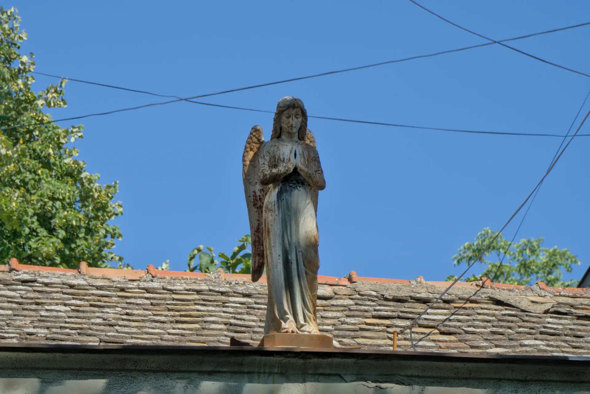 Une sculpture d'un ange sur le toit d'une maison à Novi Sad, Serbie, sur un ciel bleu.