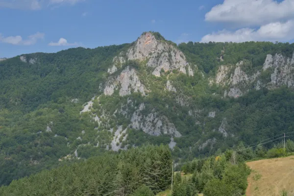 Maestosa montagna Crvena Stena in Serbia, con foreste verdi e pendii rocciosi, vista da un bar sulla strada.