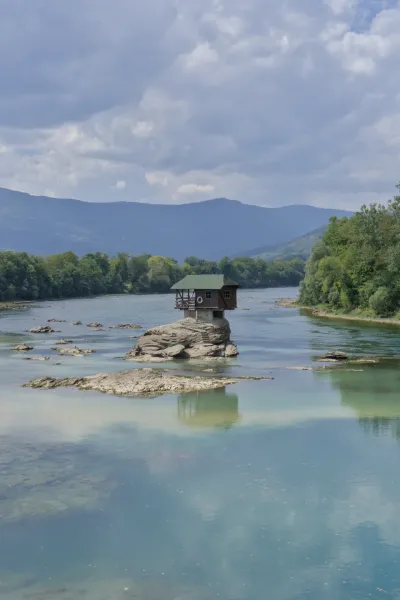 Una casa su una roccia nel fiume Drina sotto nuvole drammatiche, Bajina Bašta, Serbia.