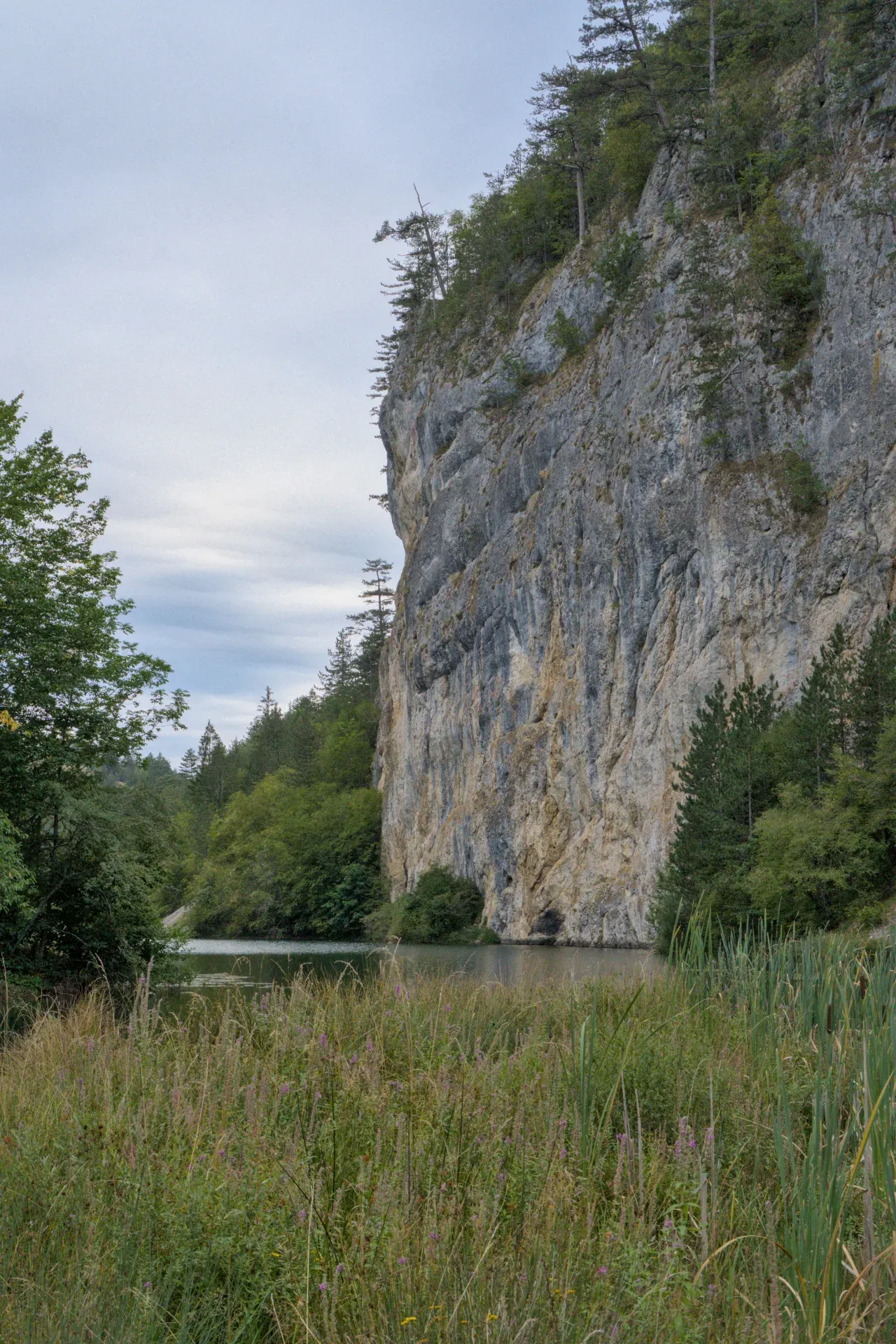 The harsh mountain landscape near Spajići Lake, with cliffs and greenery.