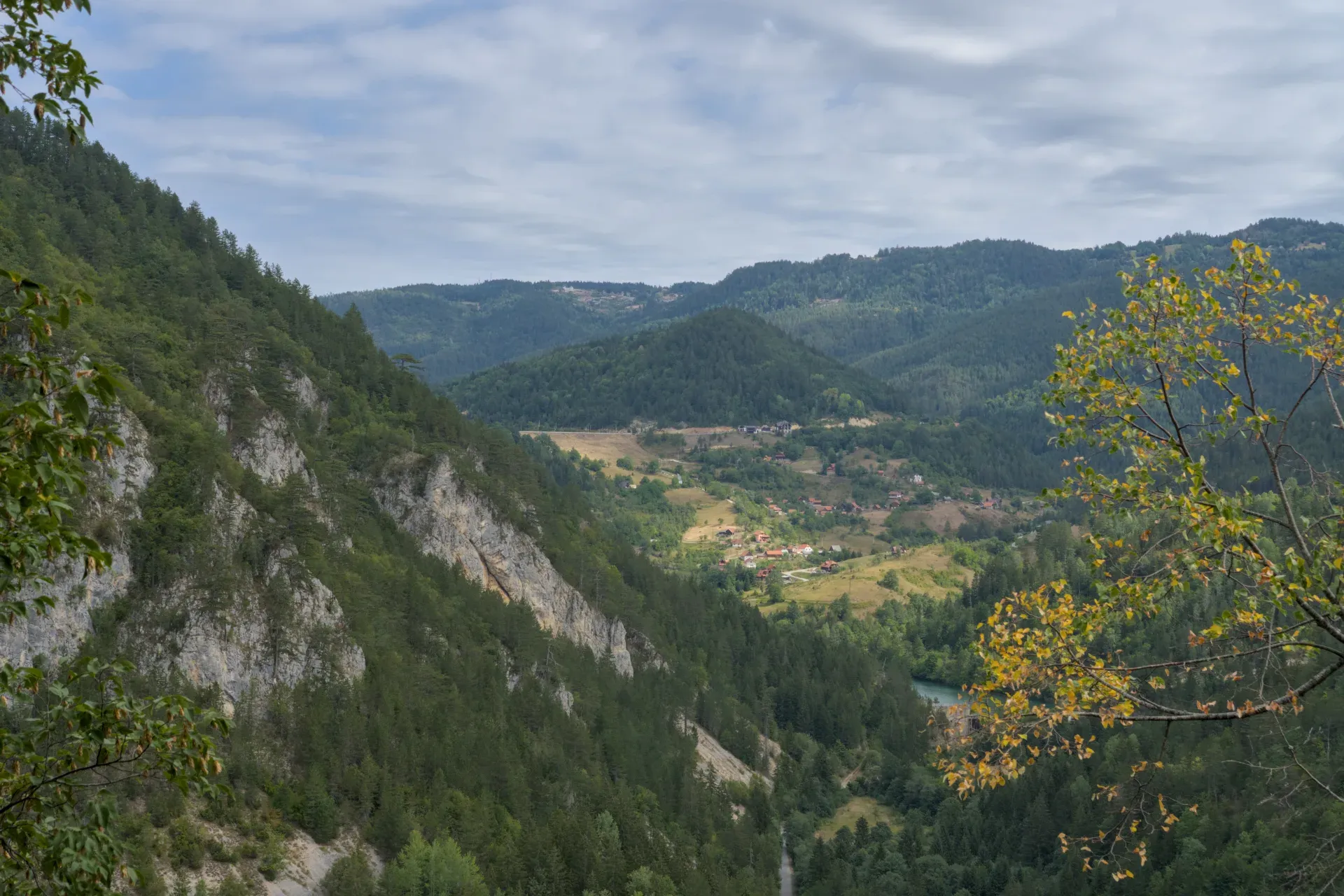 Panoramski pogled sa Ravne Stene na selo Spači u Nacionalnom parku Tara, Srbija, sa šumovitim brdima i rekom.