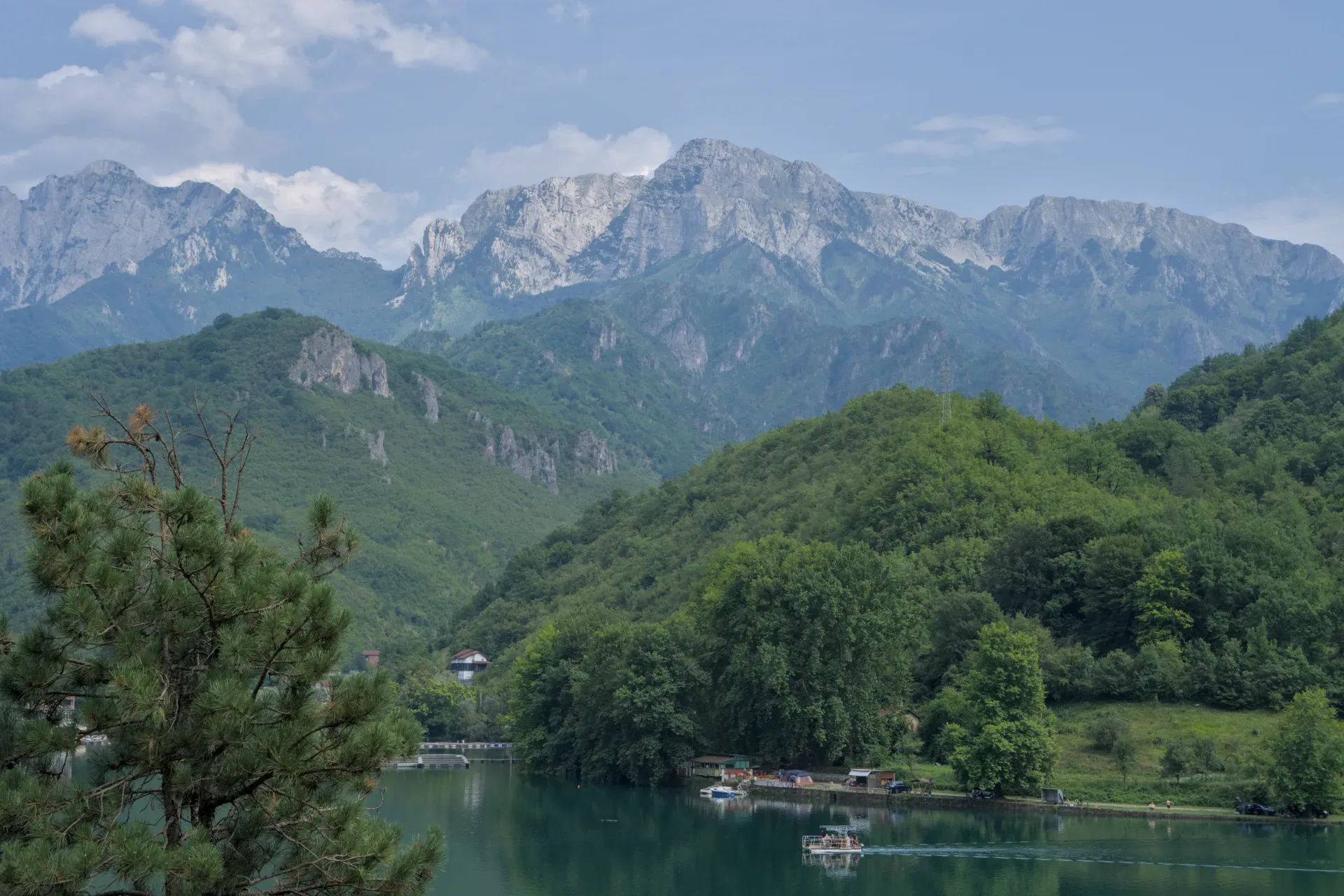 Fotografia d'arte di un bel lago sulla strada per Mostar, con montagne verdi e acqua serena.