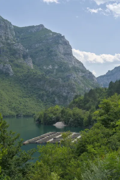 See mit Fischfarm vor majestätischen Bergen, aufgenommen auf der Route von Sarajevo nach Mostar.