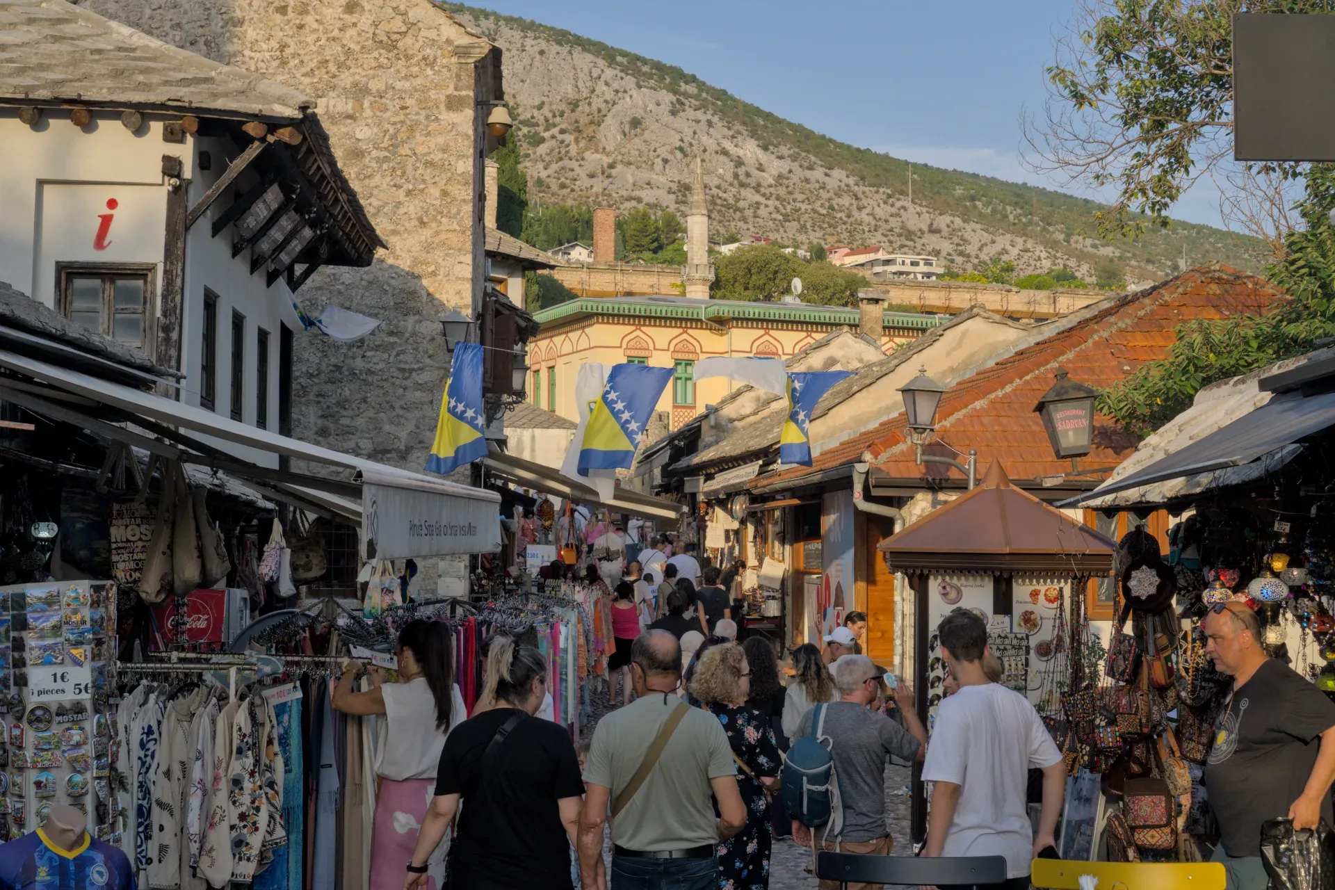 Večernje svetlo u istorijskom starom gradu Mostara, sa živahnim ulicama i tradicionalnom arhitekturom.