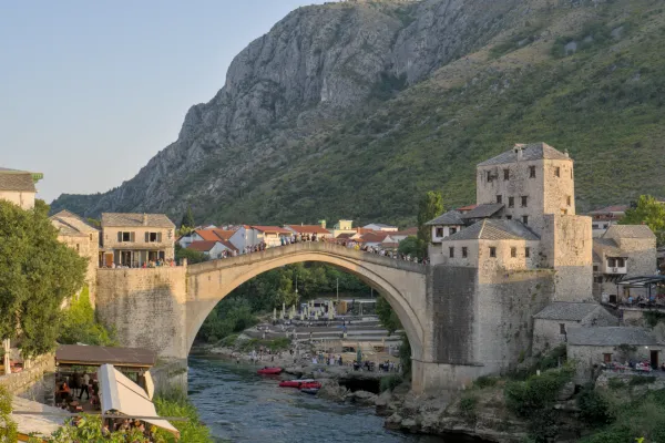 El Puente Viejo de Mostar al atardecer, destacando la arquitectura histórica y el río Neretva.