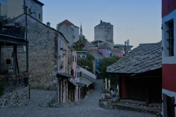 Calle empedrada en el Casco Antiguo de Mostar durante el predarassvetny chas, con edificios históricos en suave crepúsculo.