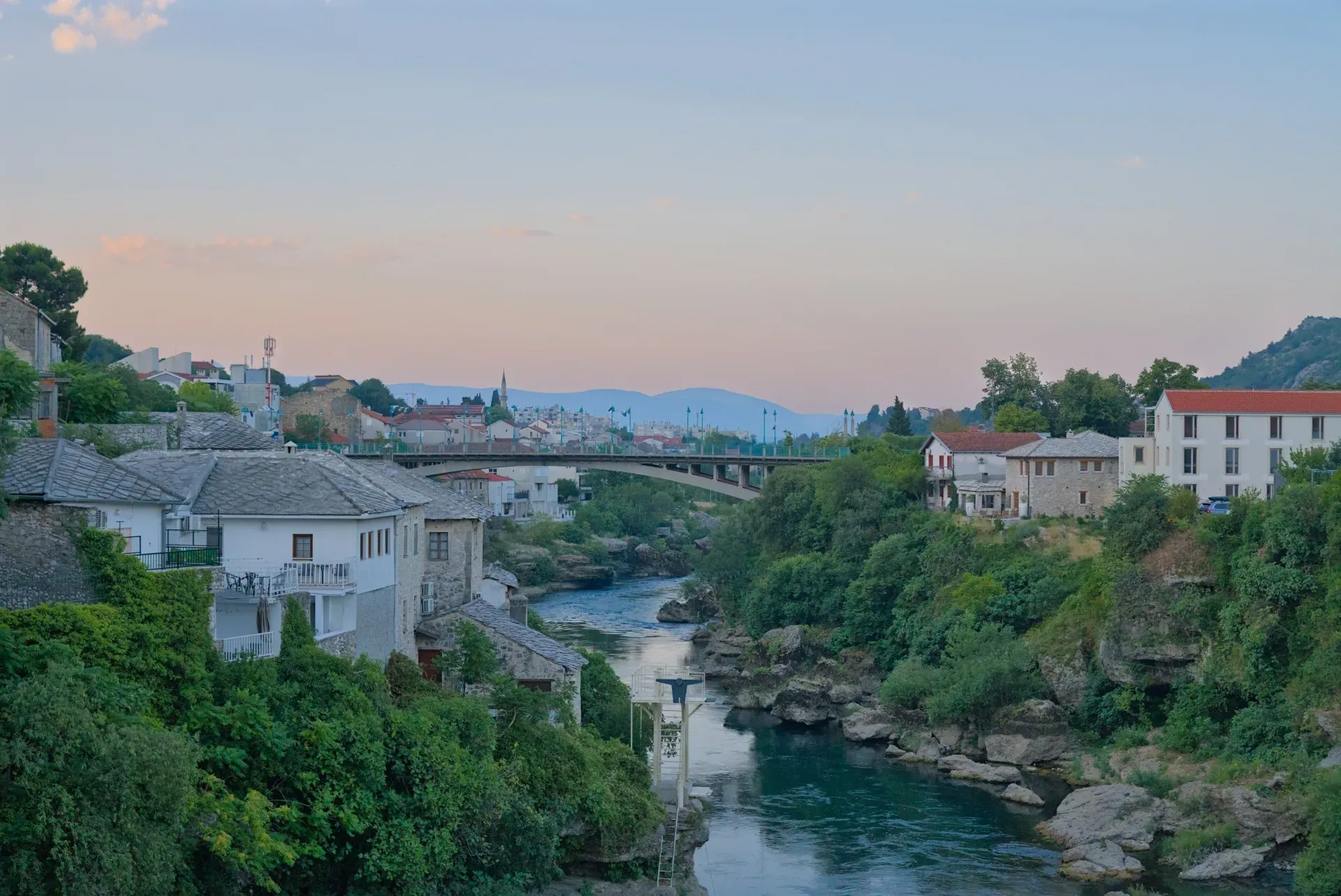 Vue du Vieux Pont de Mostar tôt le matin, avec la rivière et le pont.
