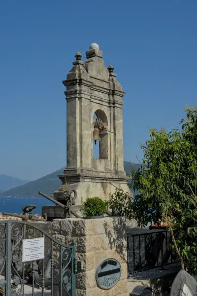 Ein alter Stein-Glockenturm mit einer Glocke im alten Stadtzentrum von Herceg Novi.