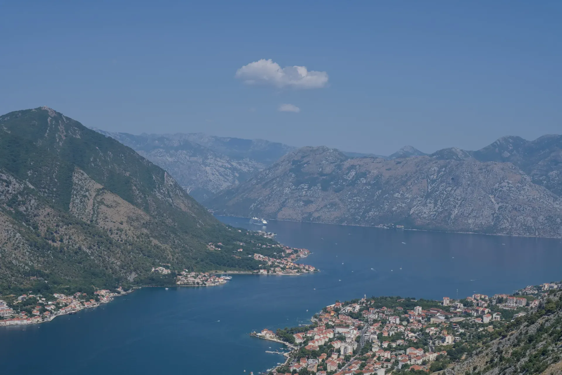 Pogled iz vazduha na kruzer koji ulazi u zaliv Kotora, sa pogledom na primorske gradove Dobrotu i Prcanj.