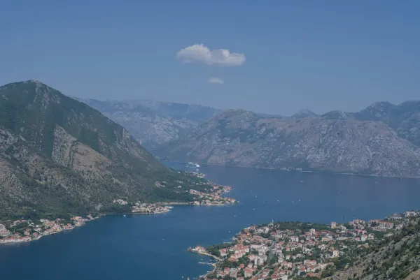 Vue aérienne d'un paquebot entrant dans la baie de Kotor, surplombant les villes côtières de Dobrota et Prcanj.