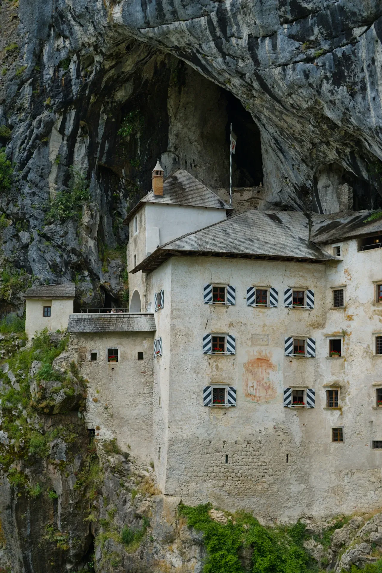 Le старинный предъямский замок в скале, un ancien château construit dans une falaise rocheuse en Slovénie, mettant en valeur l'architecture et la pierre naturelle.