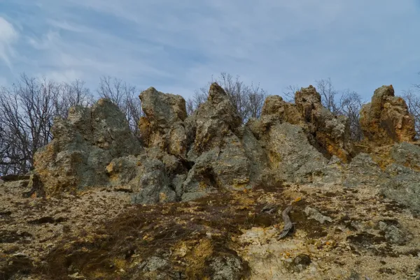 Orlovo Stijene (Eagle Rocks) in Fruška Gora, Serbia, featuring dramatic rock formations and bare trees in the background.