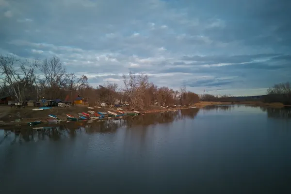 Barcos descansando en la serena orilla de Begečka Jama, Novi Sad, Serbia, bajo un cielo nublado y dramático.