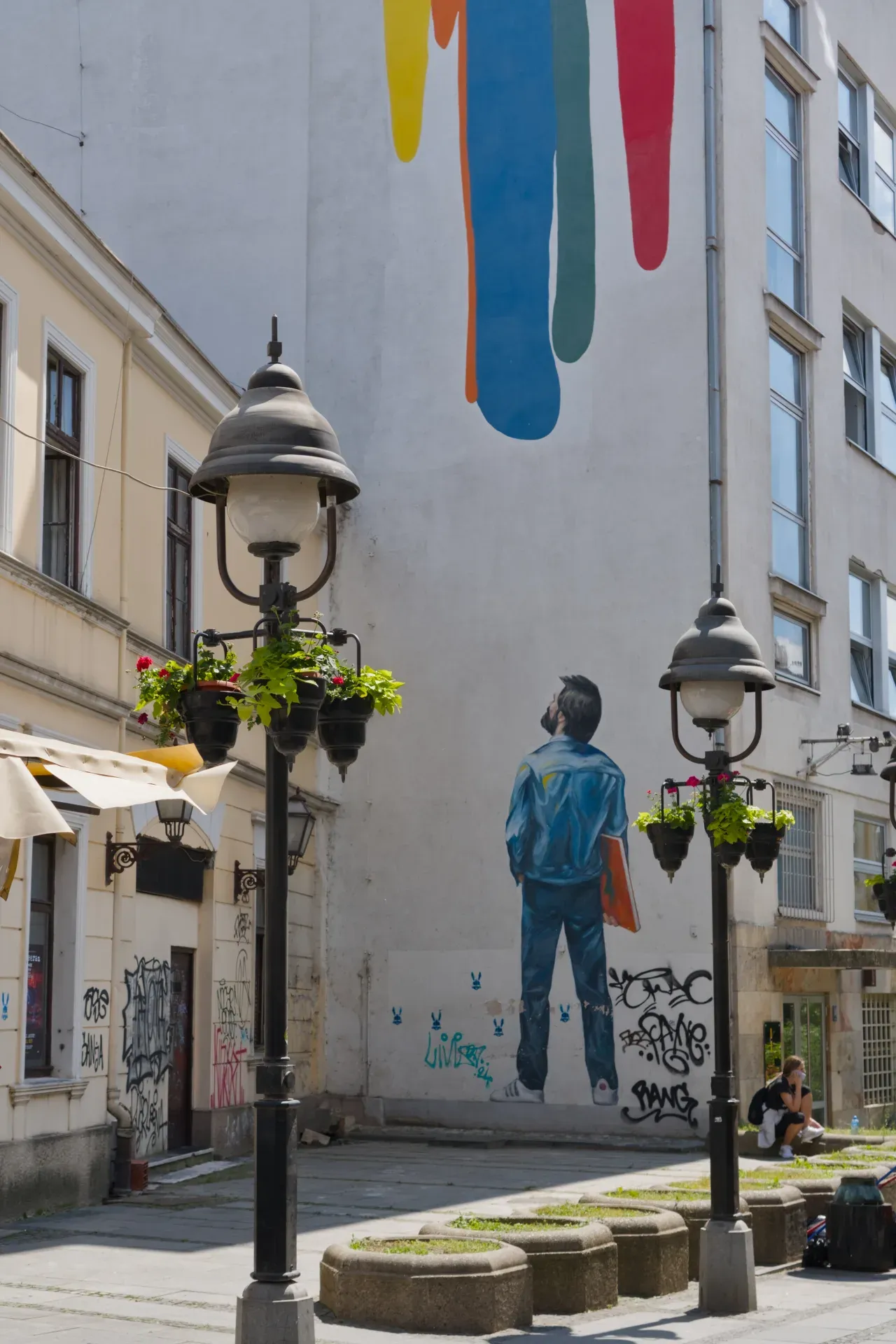 Via Knez Mihailo a Belgrado con un vivido murale stradale e lampioni.
