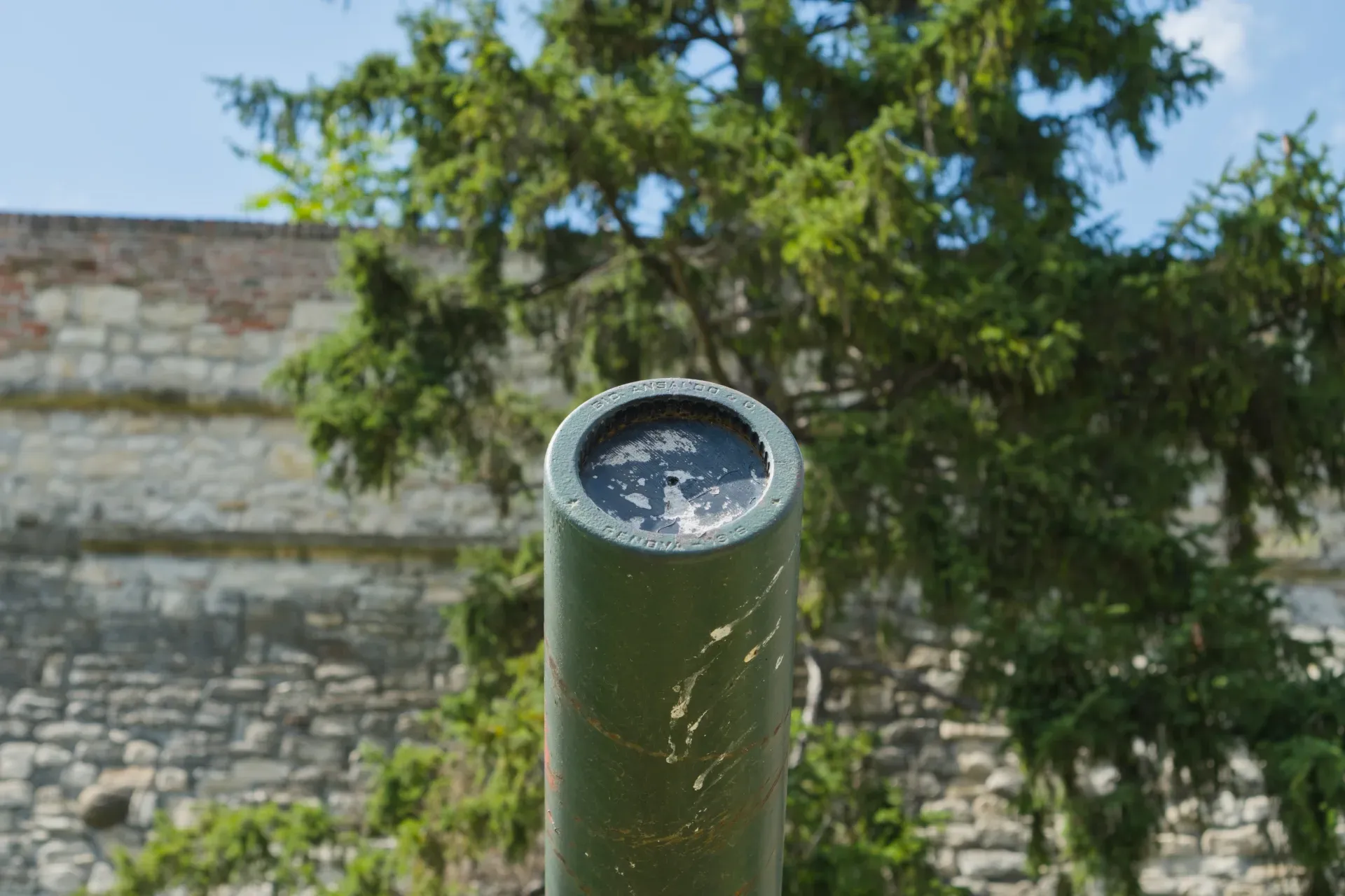 Freilichtmuseum in Kalemegdan, Belgrad: grüne Kanone vor einer Steinmauer und Bäumen.