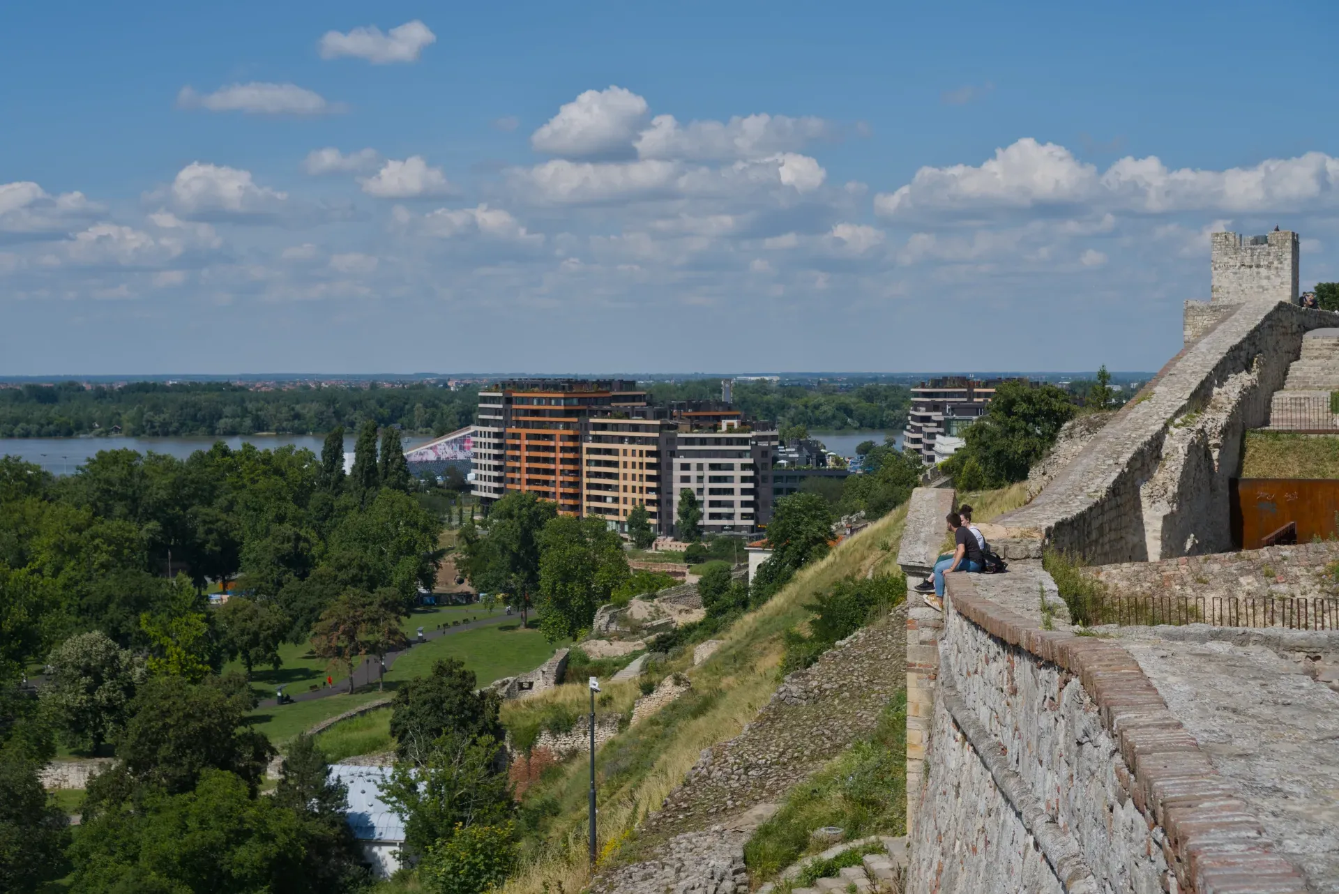 Vue depuis les murs de Kalemegdan surplombant la confluence des fleuves Sava et Danube, avec une architecture moderne en arrière-plan.