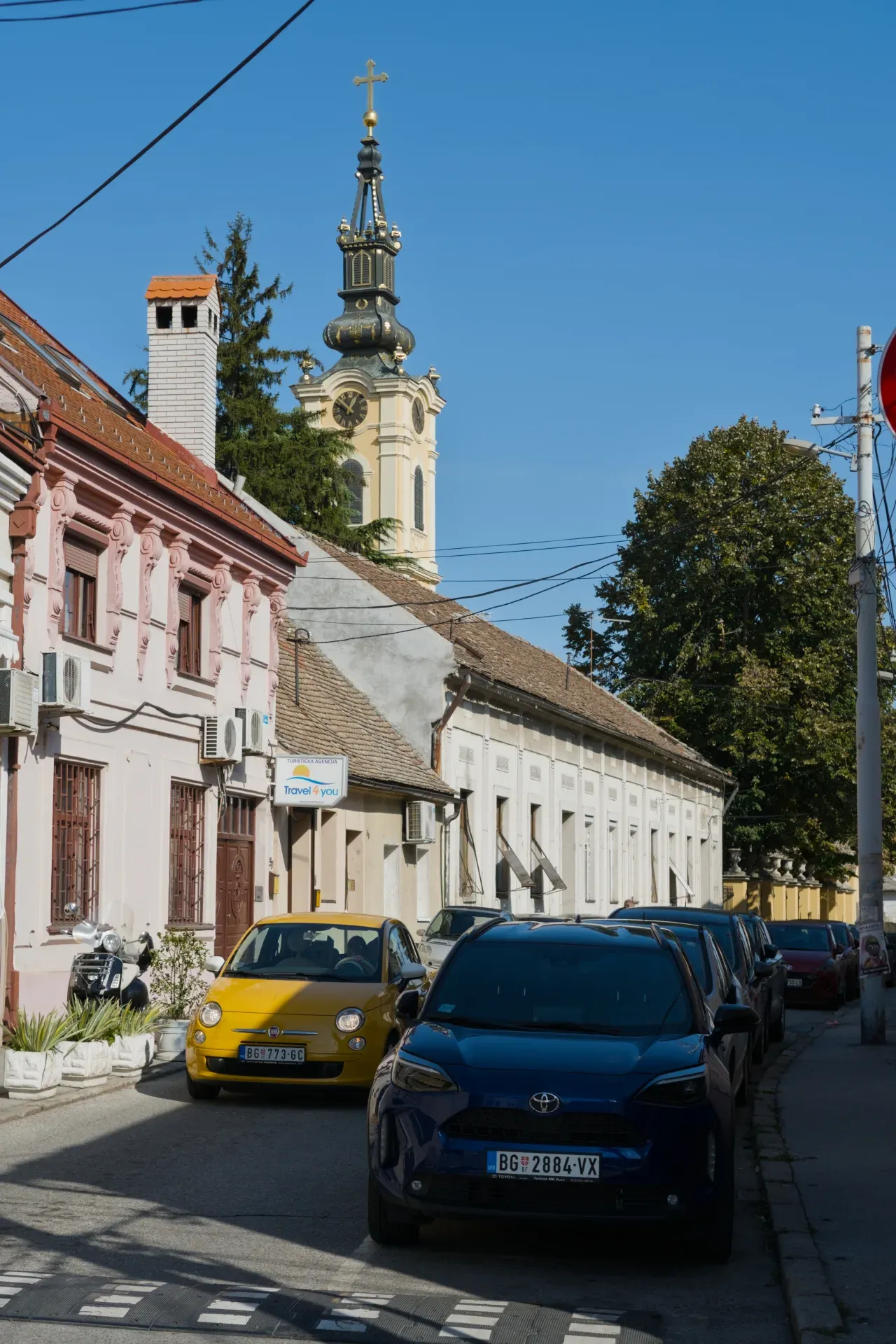 Photographie portrait d'une rue à Zemun, Belgrade, avec des bâtiments historiques et un clocher.