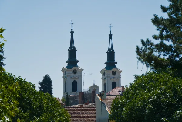 Zwei Glockentürme der Nikolaikirche in Sremski Karlovci, Serbien, vor einem klaren blauen Himmel.
