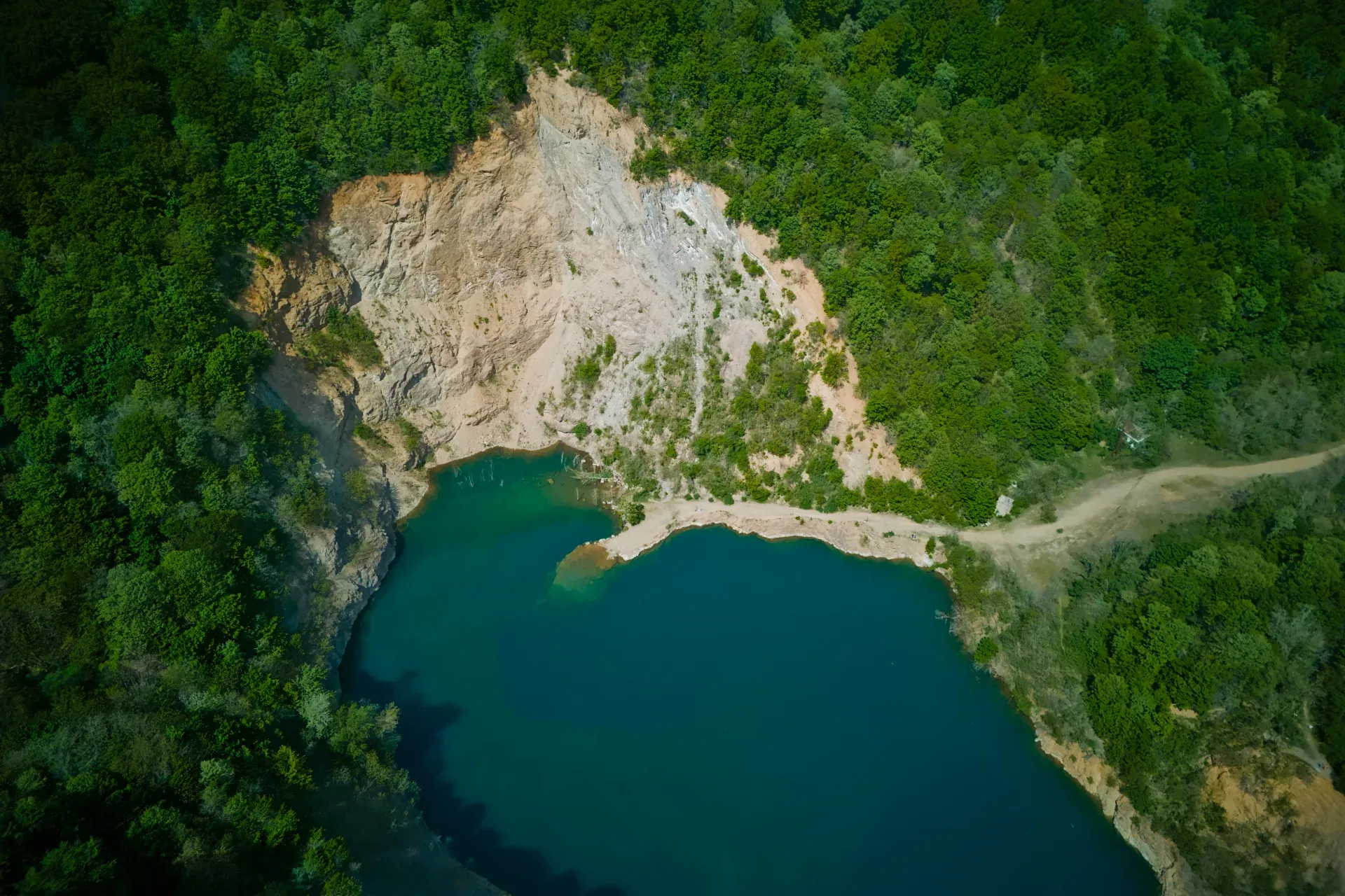 Ledinačko-See aus der Vogelperspektive, Serbien, mit türkisfarbenem Wasser und grünen Bäumen.