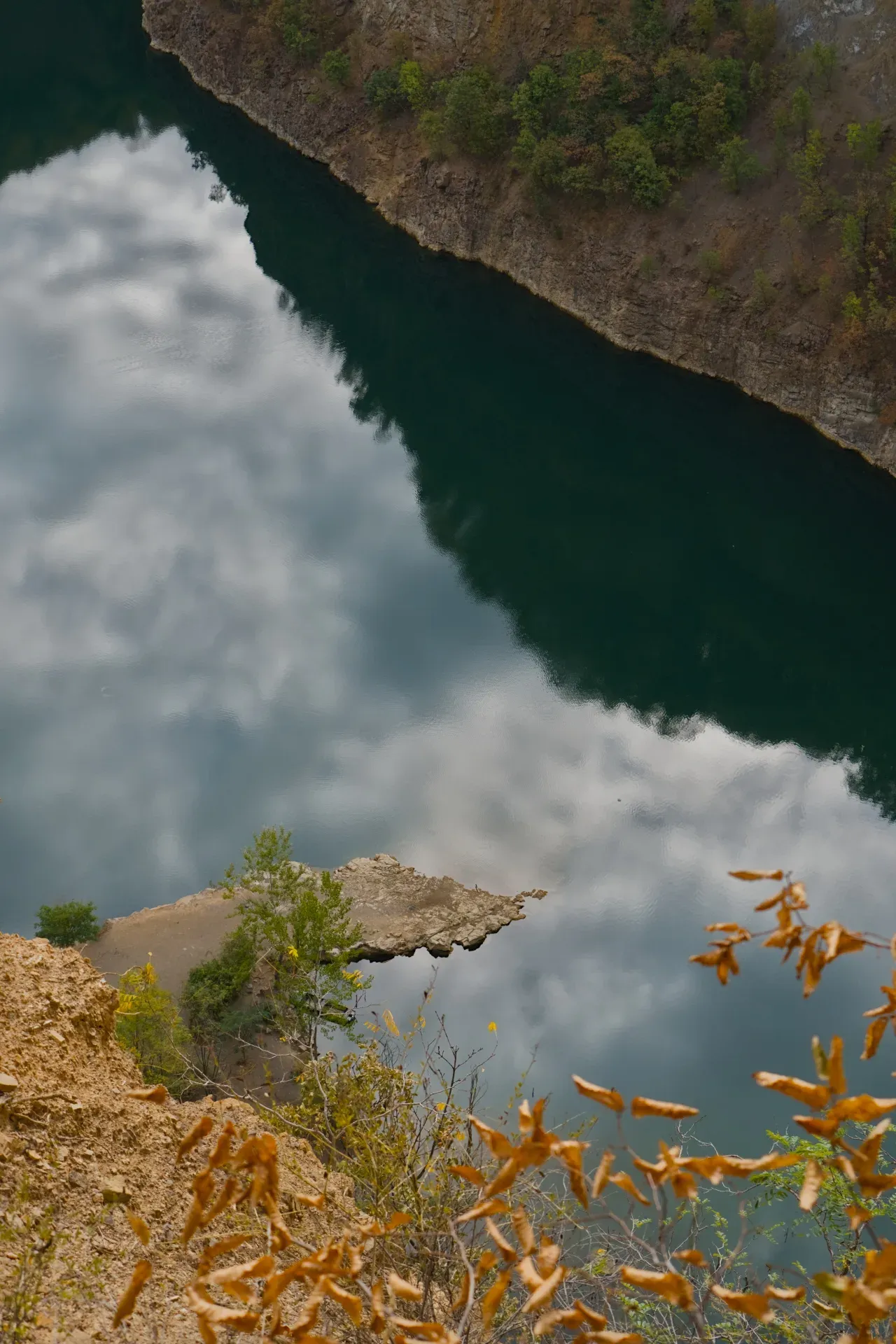Pogled na jezero Ledinačko sa litice na severozapadnoj obali, odraz oblaka u vodi.
