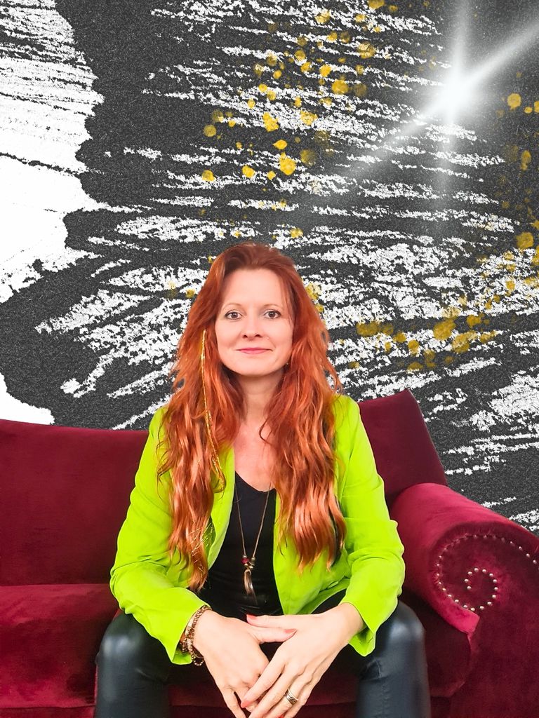 Frau mit roten Haaren auf rotem Sofa vor schwarzem Hintergrund.