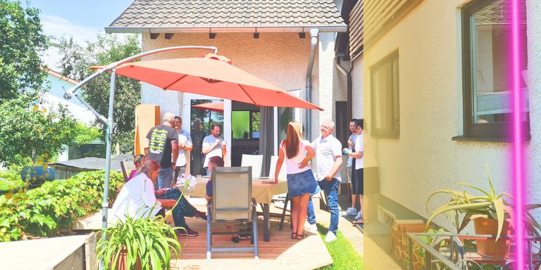 Terrasse mit Menschen unter orangefarbenen Sonnenschirm