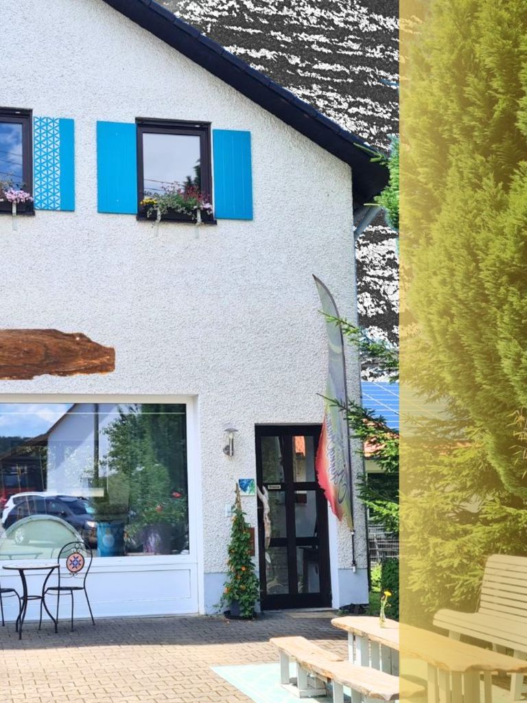 Haus mit blauen Fensterläden und schwarzer Tür.