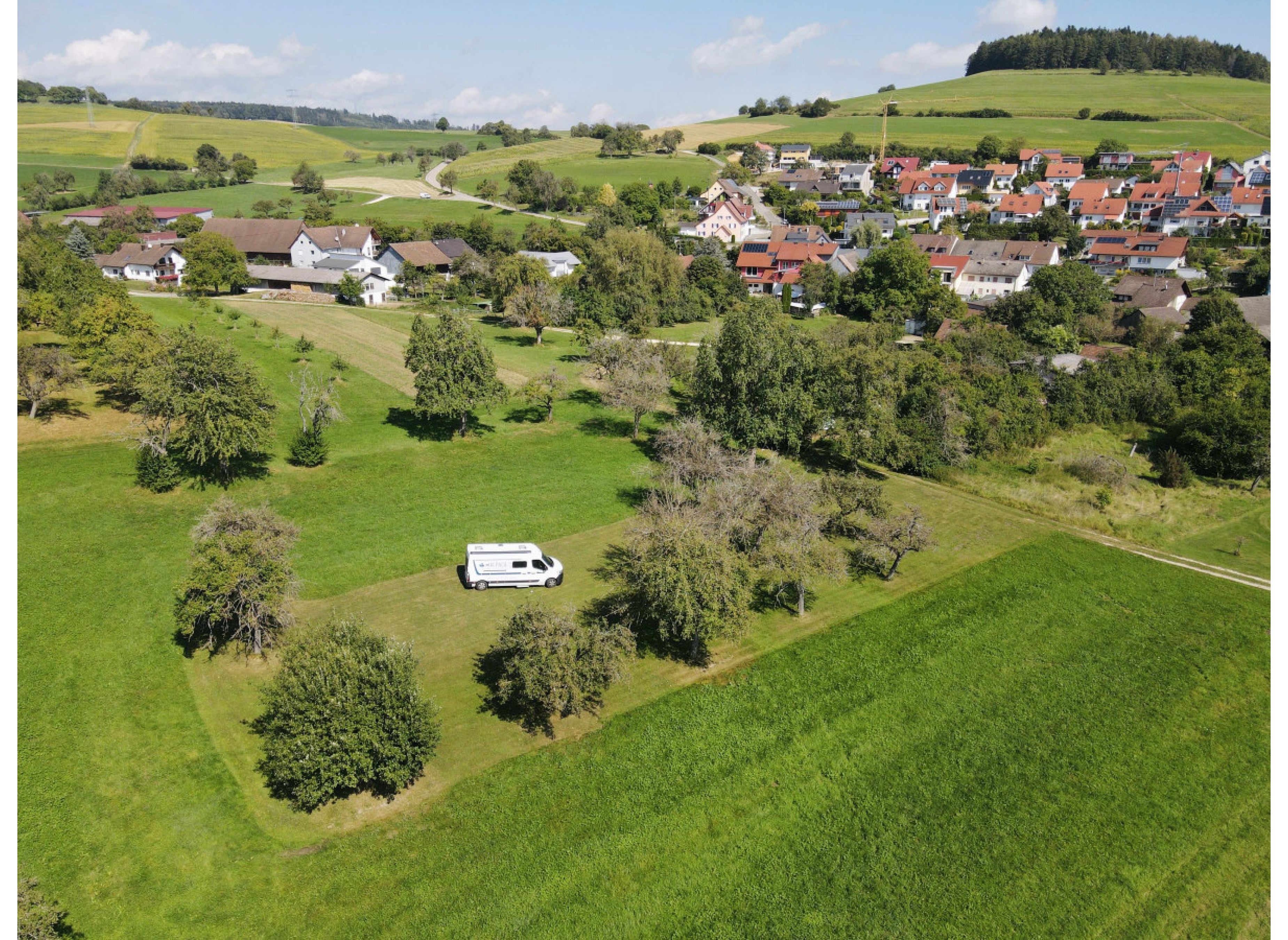 Umgeben von Bäumen auf einer grünen Wiese — Karavan Sitesi in Tengen