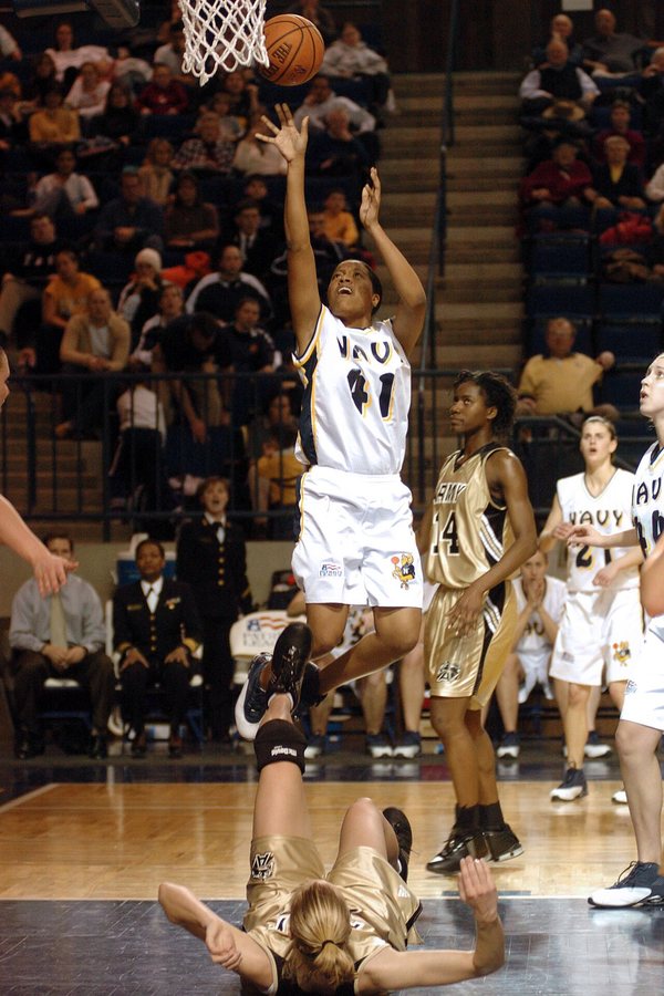 A player releases a short jump shot while her defender is either knocked down or trying to take a charge