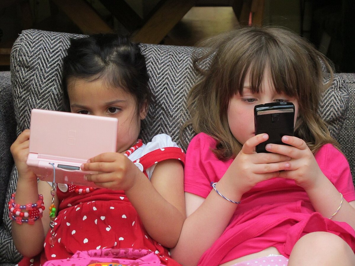 Zwei Kinder mit ihren elektronischen Geräten (2011)
