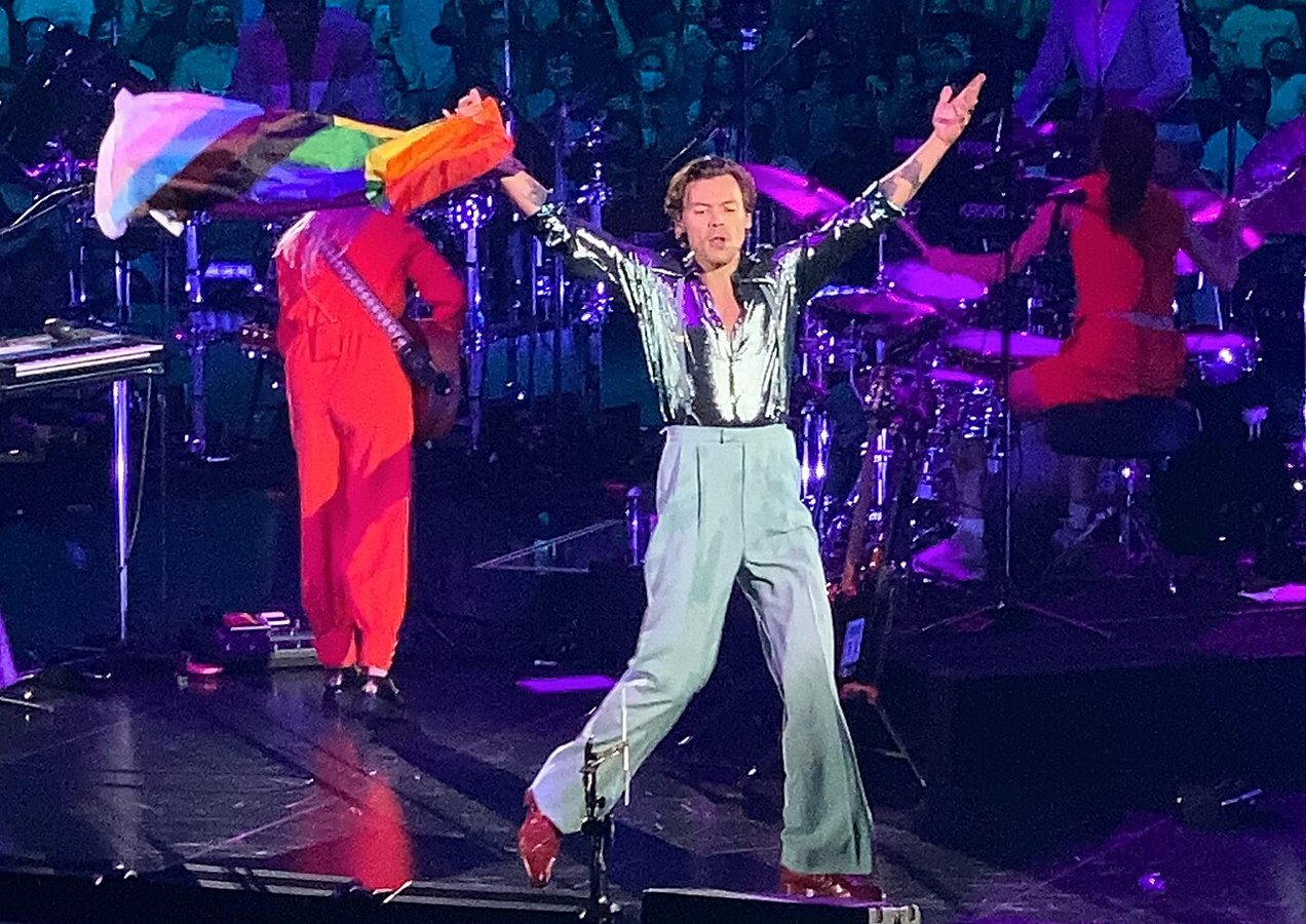 Styles machający flagą progress pride w Little Rock w stanie Arkansas w listopadzie 2021 roku