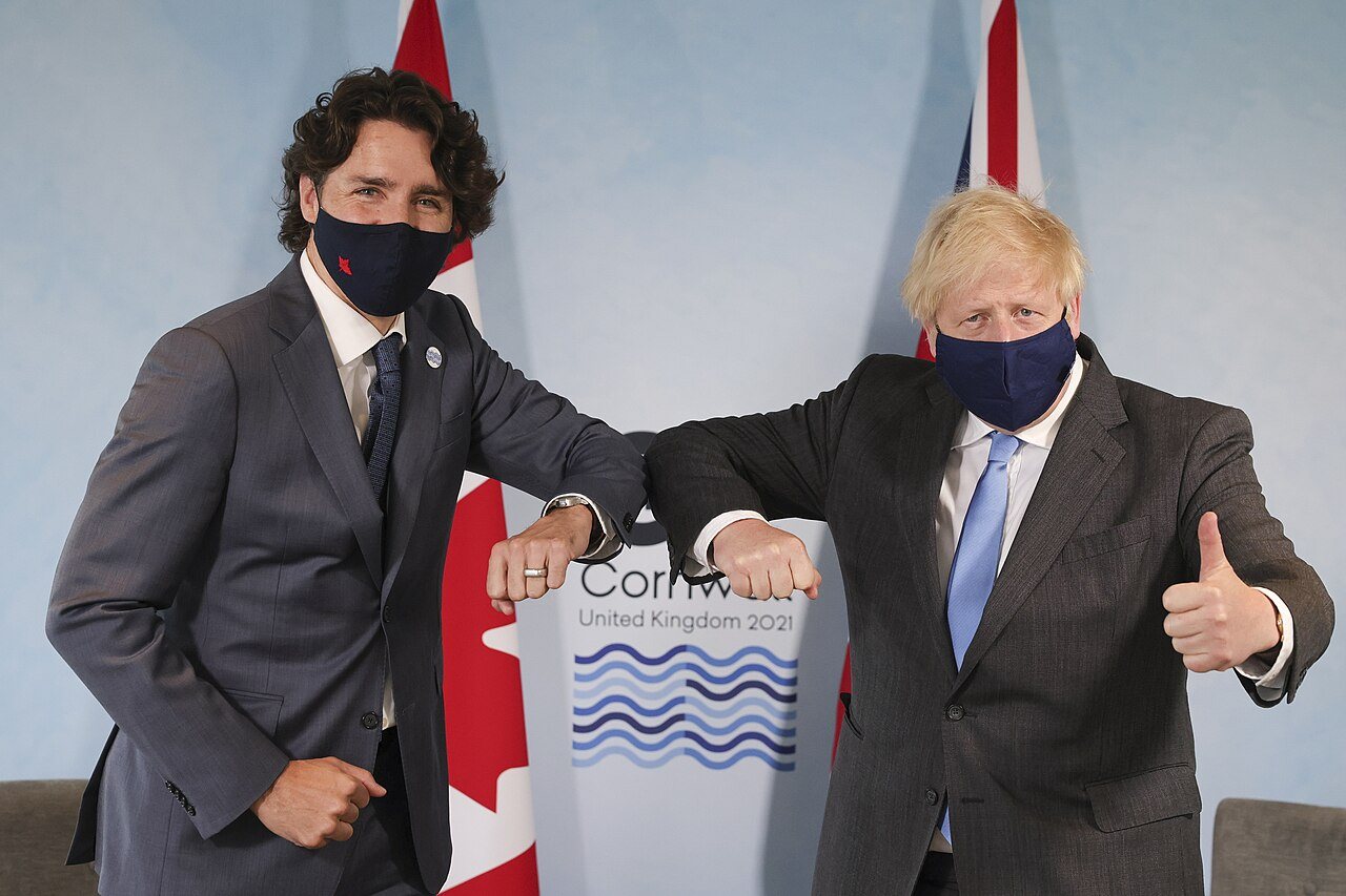 Trudeau e il primo ministro britannico Boris Johnson si salutano con un colpo di gomito indossando mascherine come precauzione contro il COVID-19 al 47º vertice del G7, giugno 2021