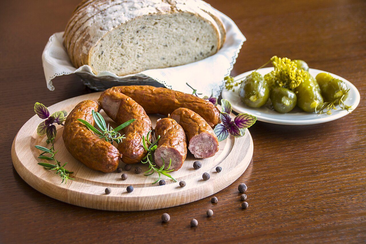 Salchicha kiełbasa, alimento básico de la cocina polaca, servida con pepinillos en vinagre y pan de centeno