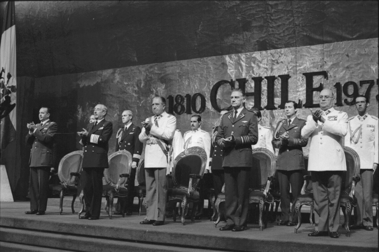 Pinochet na akci, v pozadí text s roky 1810 a 1973, rokem převratu, který jej dostal k moci