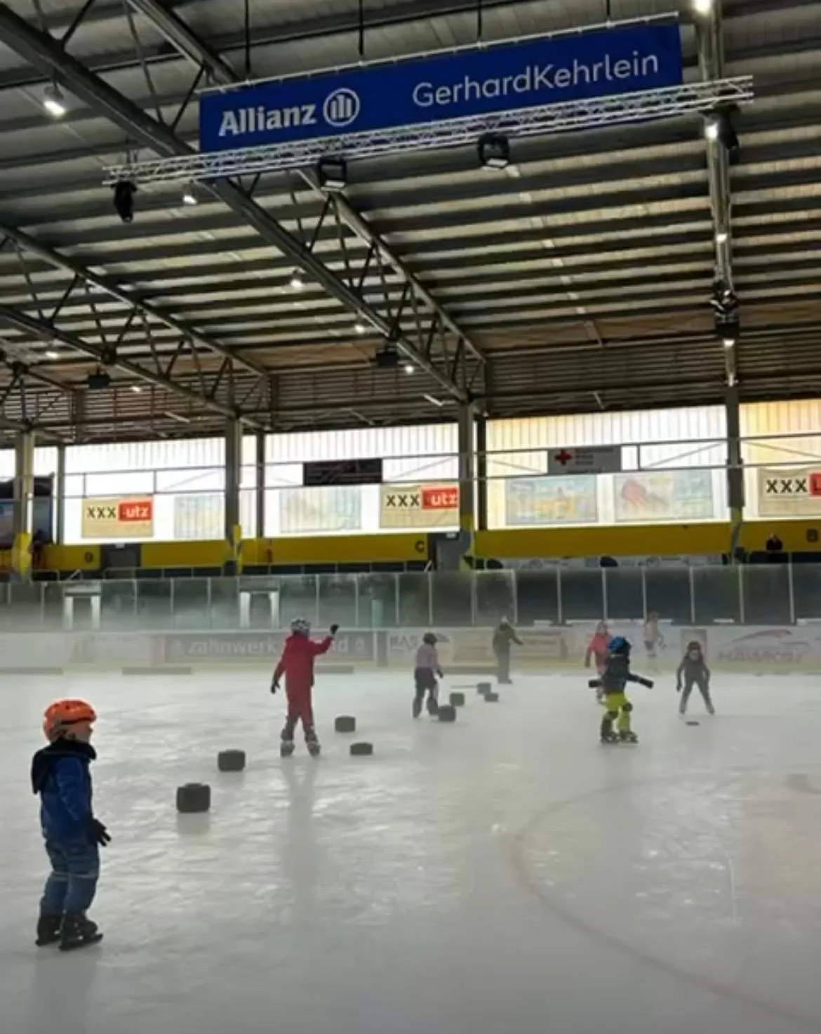Kinder der Laufschule laufen zwischen Hütchen auf dem Eis