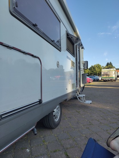 Vor einem Wohnmobil auf einem Stellplatz