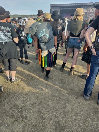 Festivalbesucher vor der Rock Harz Bühne. Eimer trägt einen Regenbogenrock