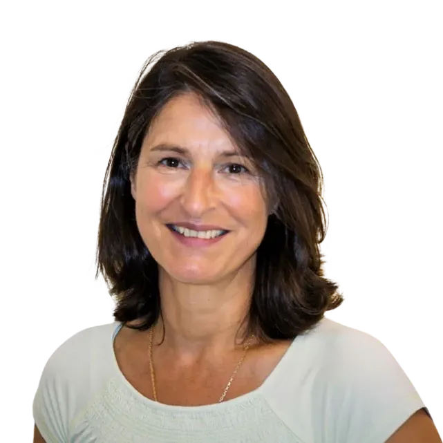 A woman with shoulder-length brown hair and a warm smile, wearing a white top and a delicate necklace, in front of a partially yellow and black background.