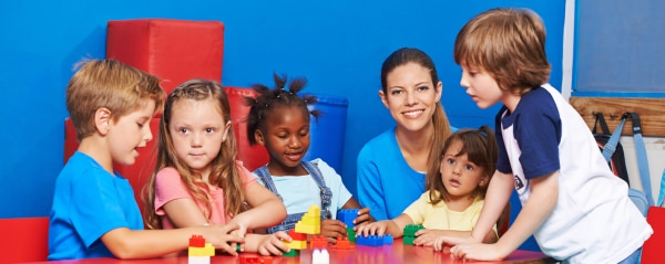 Au-Pair in Deutschland spielt mit Kindern der Gastfamilie