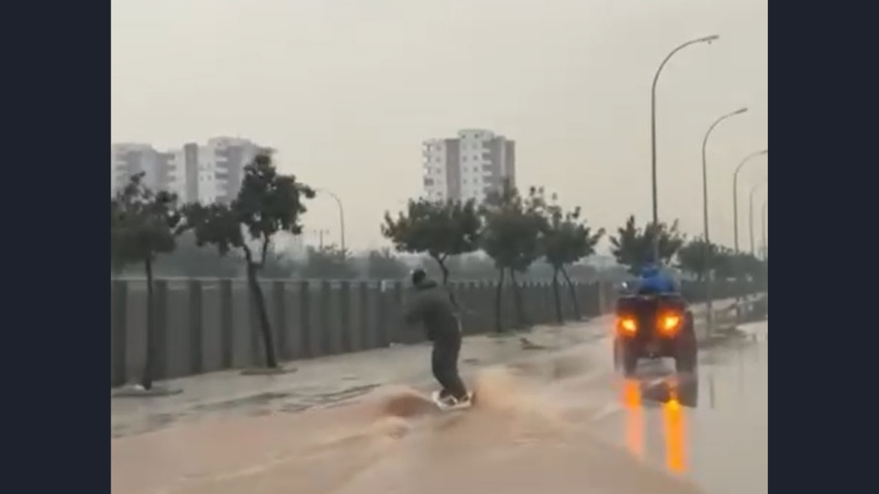 Adana'da sağanak sonrası şaşırtan görüntü: Su basan caddede sörf yaptı