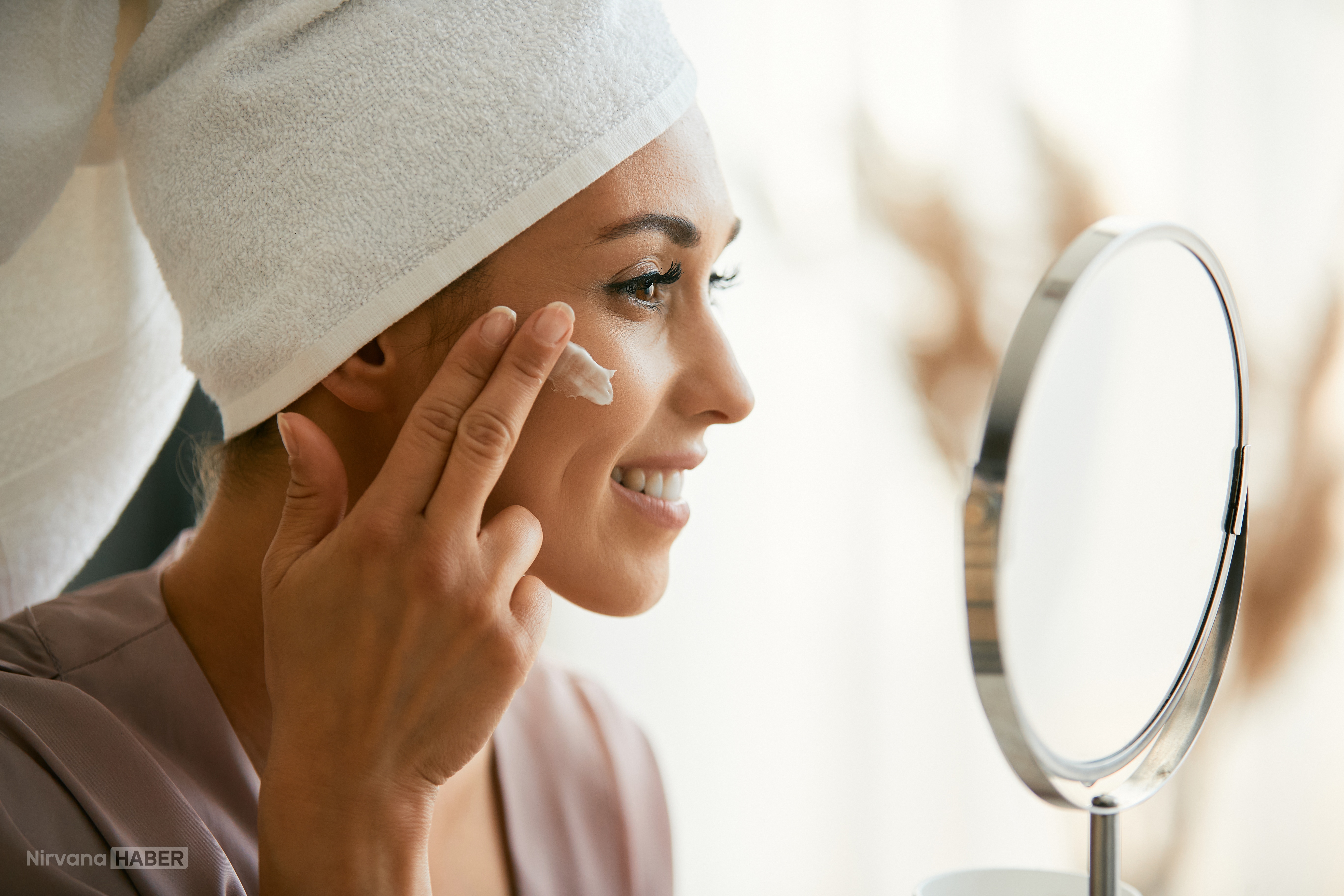 beautiful-woman-applying-face-cream-while-looking-2026-03-16-03-30-46-utc.jpg