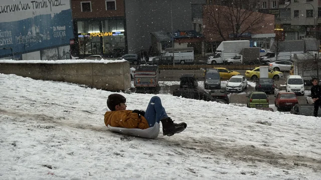 Erzurum'da kar yağışını fırsat bilen çocuklar mahalle aralarında poşetlerle kaydı