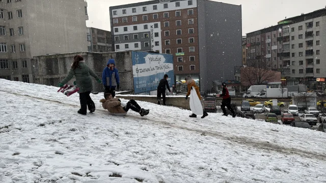 Erzurum'da kar yağışını fırsat bilen çocuklar mahalle aralarında poşetlerle kaydı