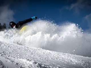 Robbin geniet van boarden in de verse sneeuw op wintersport in Oostenrijk 