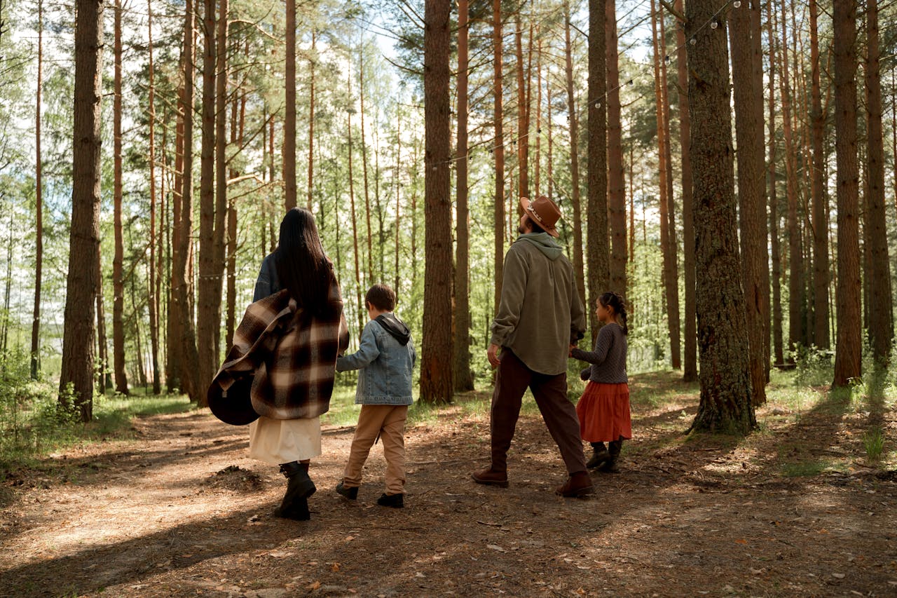 Familie mit zwei Kindern, die im Wald spazieren geht