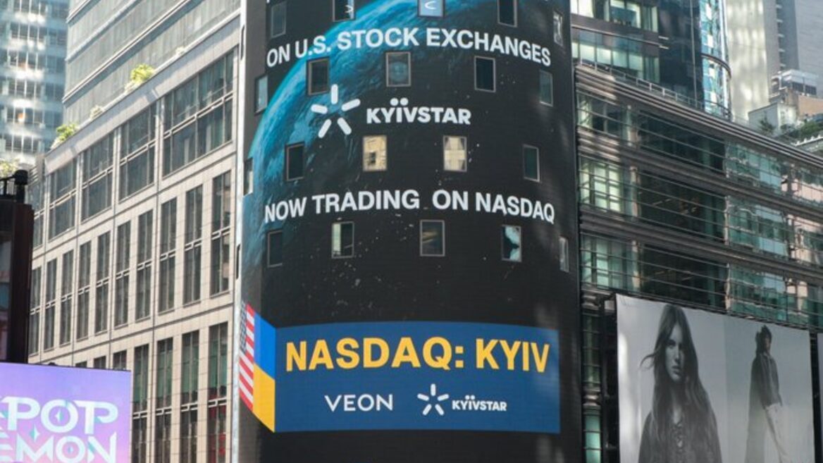 Cylindrical digital billboard in a city announcing NASDAQ: KYIV for Kyivstar with the Earth graphic and 'Now trading on NASDAQ' text.